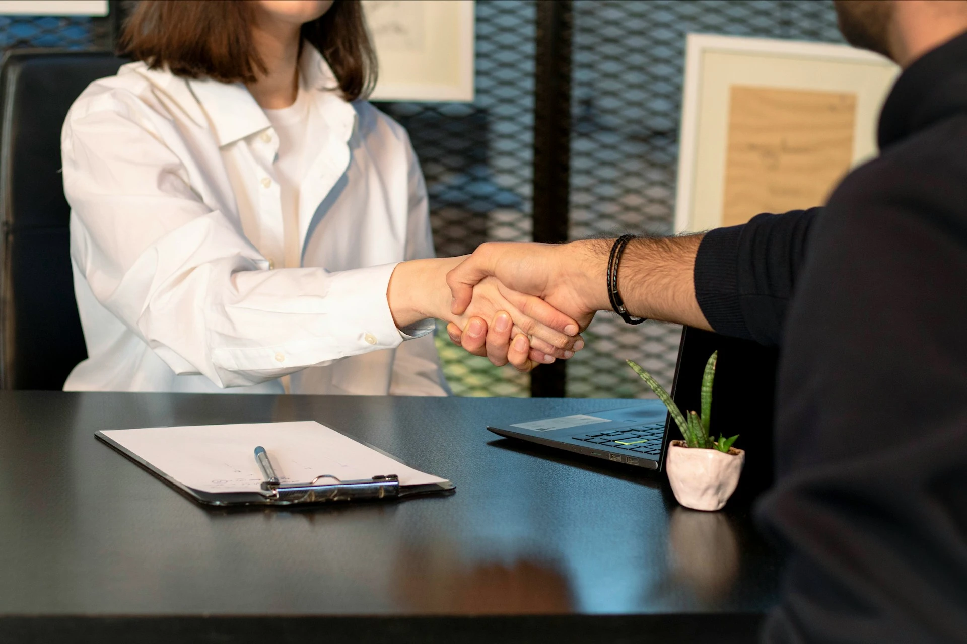 Two people shaking their hands in a interview job