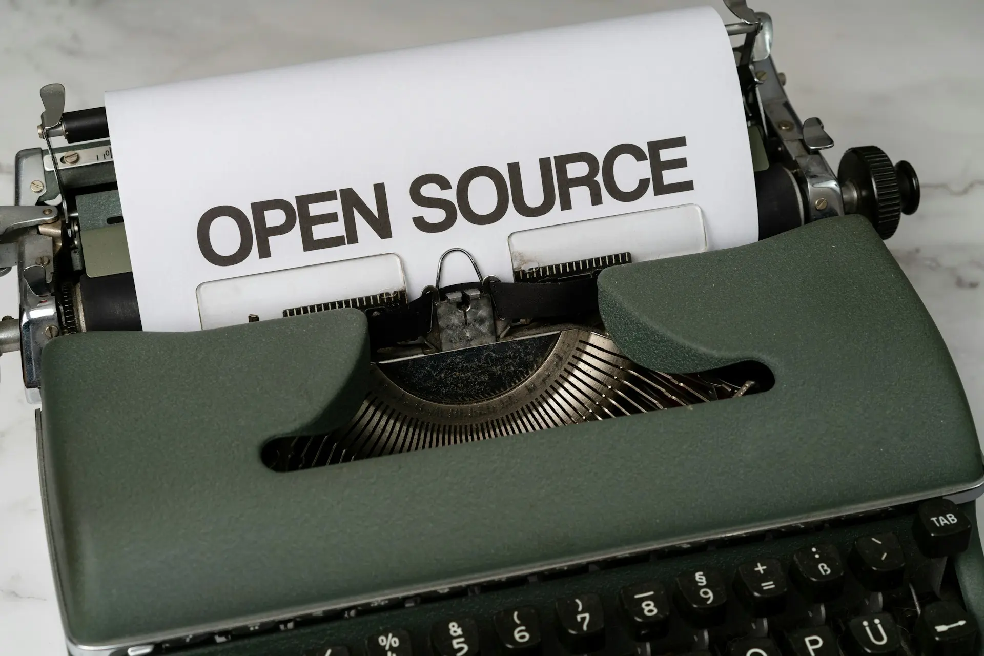 typewriter with a sheet of paper that reads "open source"